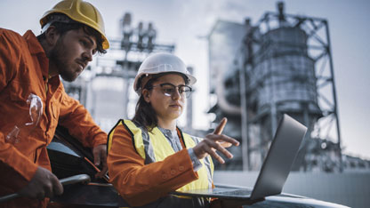 Echipa de ingineri de teren care lucrează la revizuirea rapoartelor pe un laptop