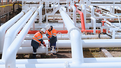 experți care lucrează la fața locului, cu țevi mari